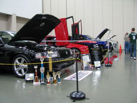 2003 Mercury Marauder - Several custom cars are displayed indoors with their hoods and doors open, some with trophies.