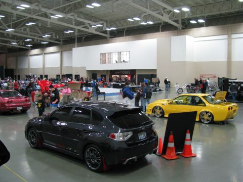 2003 Mercury Marauder - A black hatchback is displayed at an indoor automotive event alongside other vehicles.