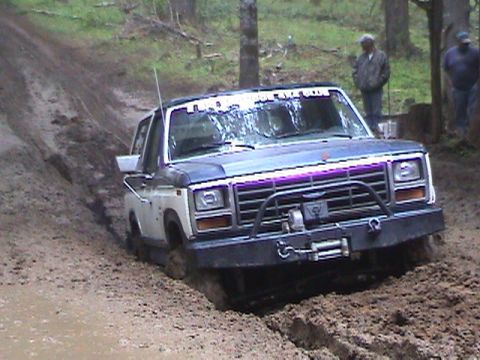1994 Ford Explorer - This two-tone pickup truck, likely from the early 1980s, is stuck in the mud with a winch attached to its front bumper.