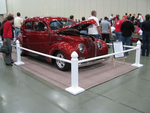2003 Mercury Marauder - A classic red sedan, likely a 1939 model, is displayed with its hood open at a car show.