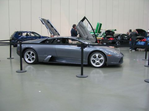 2003 Mercury Marauder - A gray Lamborghini Murciélago is displayed with its doors open at an indoor car show.