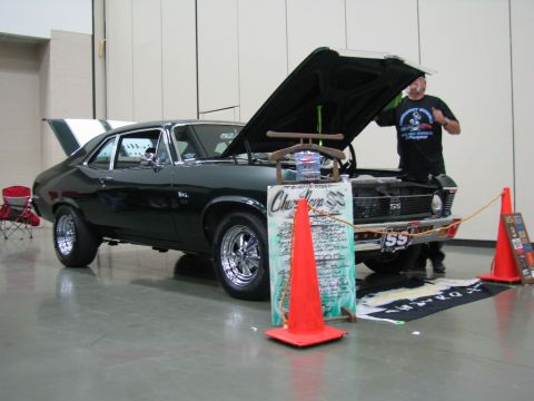 2003 Mercury Marauder - A dark green 1969 Chevrolet Nova SS coupe is displayed with its hood open at a car show.