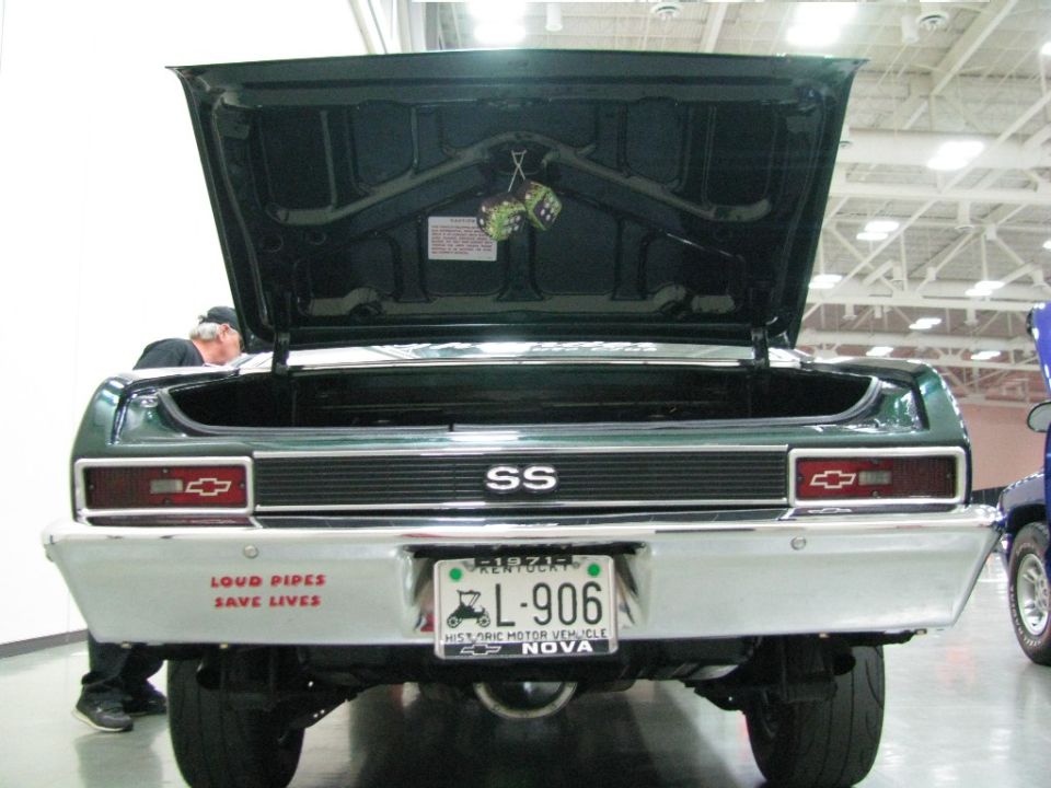 Green Chevrolet Nova SS rear view with trunk open, "SS" emblem, and custom plate