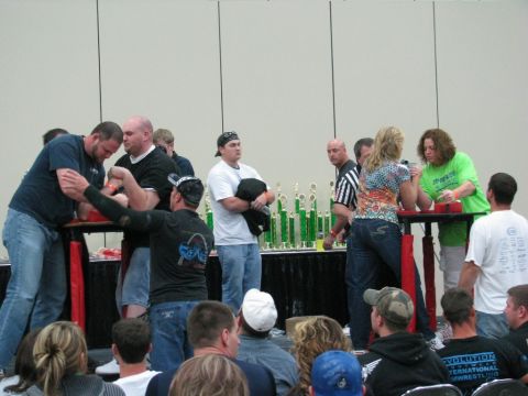 2003 Mercury Marauder - Arm wrestling competition with trophies displayed on a table behind the competitors.