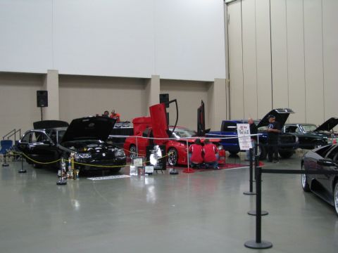 2003 Mercury Marauder - Multiple vehicles are displayed indoors at a car show, with some hoods and doors open.