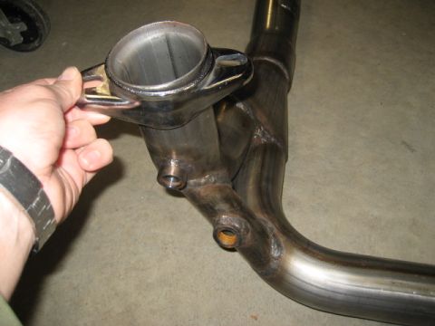 1996 Ford Bronco - A close-up view of a custom exhaust pipe assembly, showing its metallic construction and welded joints.