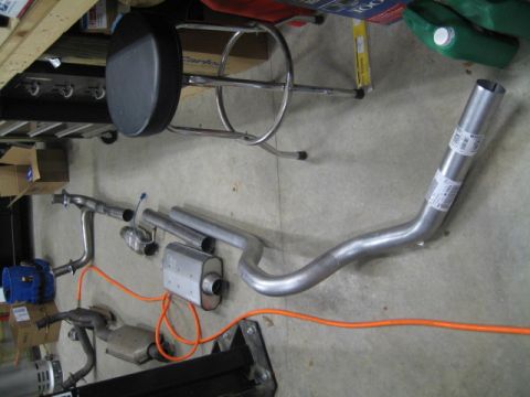 1996 Ford Bronco - Various components of a vehicle's exhaust system are displayed on the ground.