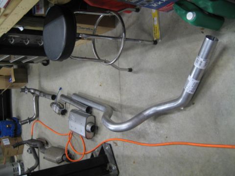 1996 Ford Bronco - Various exhaust system components are visible on the floor, including pipes and a muffler.