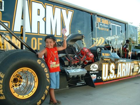 1991 Ford Bronco - A child poses with a U.S. Army dragster in front of a large trailer.