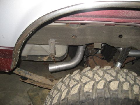 1996 Ford Bronco - The underside of a vehicle, focusing on the exhaust system and a large tire.