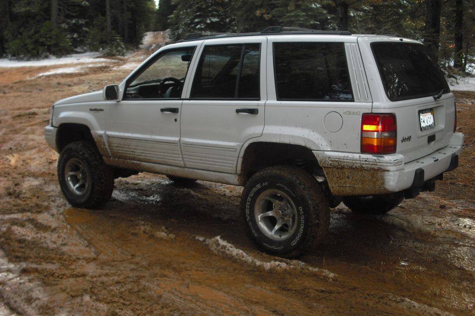 White Jeep Grand Cherokee on muddy trail