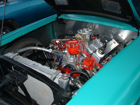 1991 Ford Bronco - The engine compartment of a custom car showcases a powerful V8 engine with various performance upgrades.