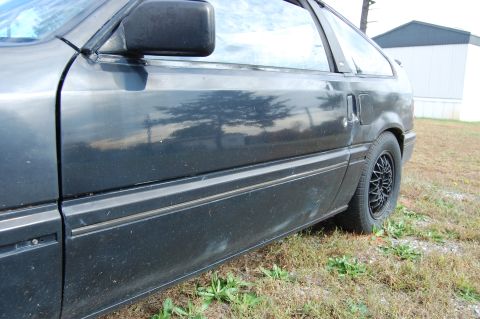 1996 Ford Probe - Side profile of a car showing the door panel, side molding, and rear wheel.