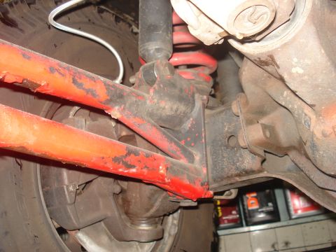 1986 Ford Bronco - Close-up view of the vehicle's suspension system, showing painted components and a shock absorber.