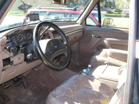 1992 Ford Bronco - Interior view of a 1992 Ford Bronco, showing the dashboard, steering wheel, and worn leather seats.