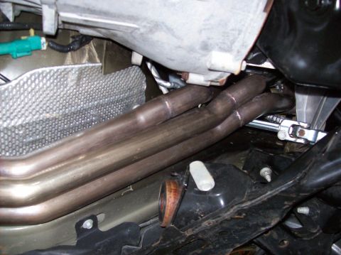 2007 Ford Mustang - Close-up view of exhaust headers and associated engine parts.