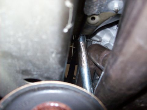 2007 Ford Mustang - Close-up view of exhaust headers and engine components, taken from underneath a vehicle.