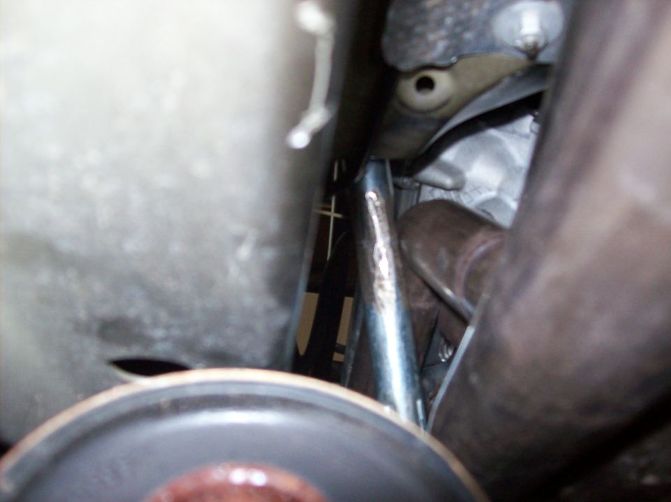 Close-up underbody view of metal bracket and component near oil filter