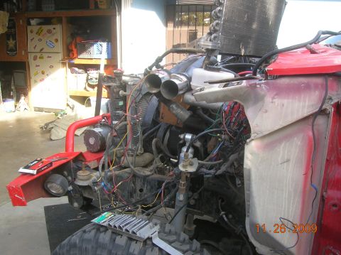 1985 Ford Bronco - The vehicle's engine bay is exposed, showing extensive wiring and components during a rebuild or repair process.