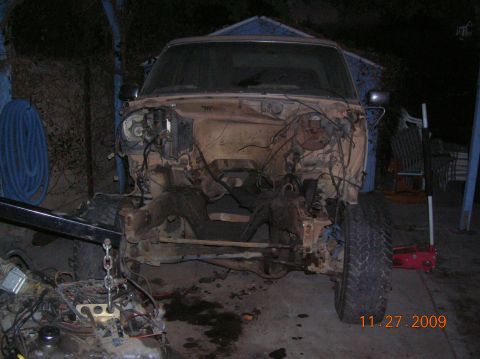 1985 Ford Bronco - Front end of a 1985 Ford Bronco disassembled, showing the engine bay and chassis.