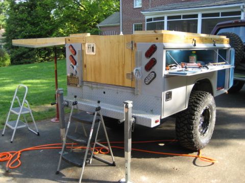 1996 Ford Bronco - A custom utility trailer with a wooden box and open tool storage is parked next to an SUV.