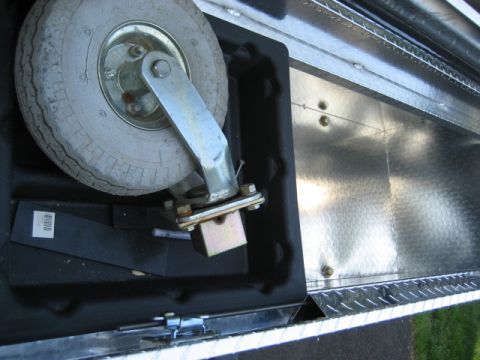 1996 Ford Bronco - Close-up view of a caster wheel assembly, likely for a trailer, showing its mounting bracket and tire.