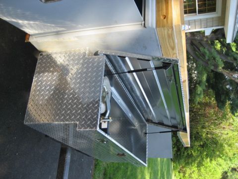 1996 Ford Bronco - Open diamond plate truck bed tool box with gas struts visible.