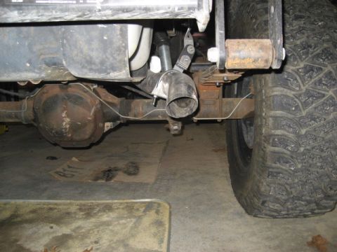 1996 Ford Bronco - Close-up view of the undercarriage of a vehicle, focusing on the rear axle and exhaust system.