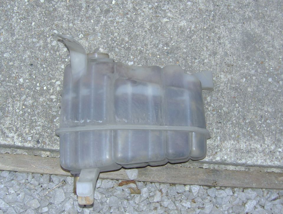 Plastic coolant reservoir tank with hoses attached
