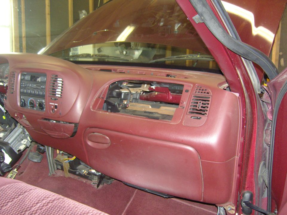 Burgundy pickup dashboard with top panel removed exposing HVAC ducting, passenger side