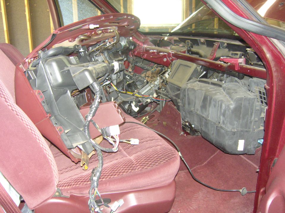 Truck interior with dash removed and HVAC heater box pulled out during a heater core repair