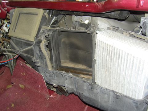 2007 Ford Mustang - The HVAC plenum opened up behind the removed dashboard, with the evaporator/heater core cavity exposed and a clean white-finned core seated…