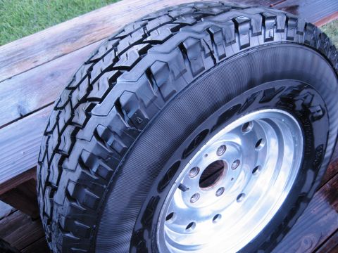 1986 Ford Bronco - Tire and rim assembly resting on wooden planks.