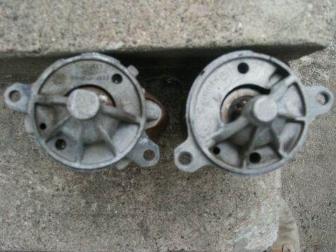 1966 Ford Bronco - Two starter motors, one with visible Ford branding, rest on a concrete surface.