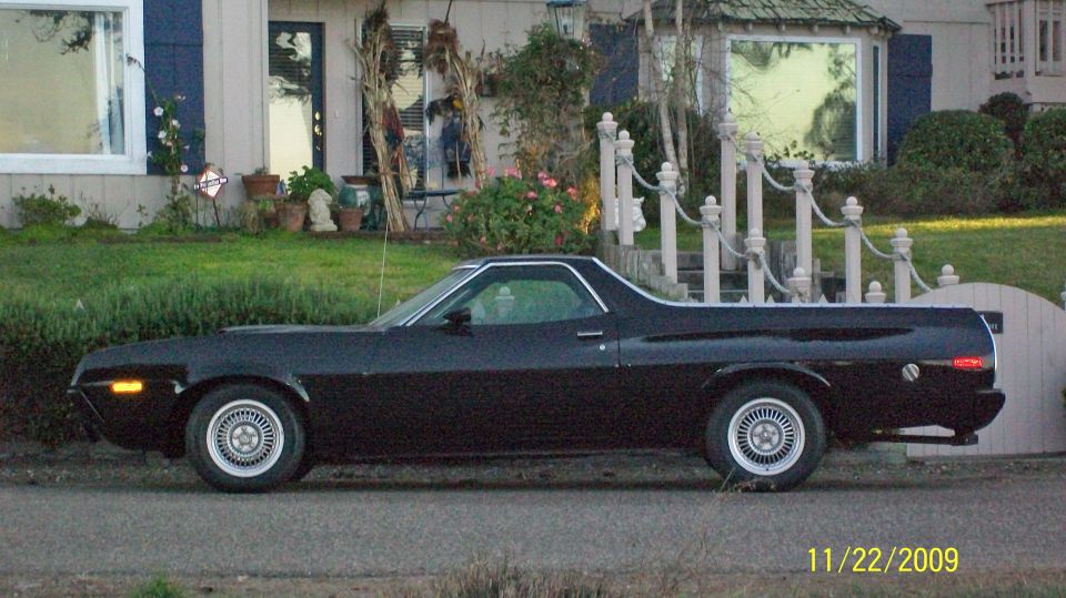 Black 1972 Ford Ranchero parked in front of a house