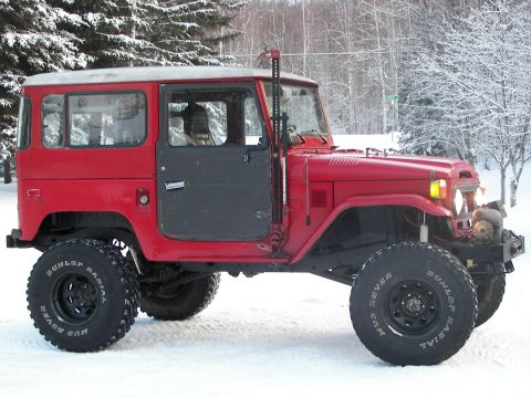 1990 Chevrolet Suburban - This red Toyota Land Cruiser FJ40 is equipped with a Hi-Lift jack and large mud-terrain tires.