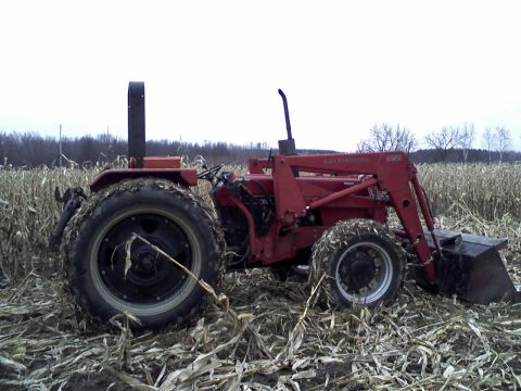 2000 Chevrolet Tahoe - Tractor with front loader in a cornfield, showing side profile and large rear tires.