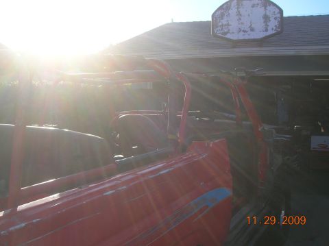 1985 Ford Bronco - Red off-road vehicle with roll cage and side stripes, photographed on 11.29.2009.