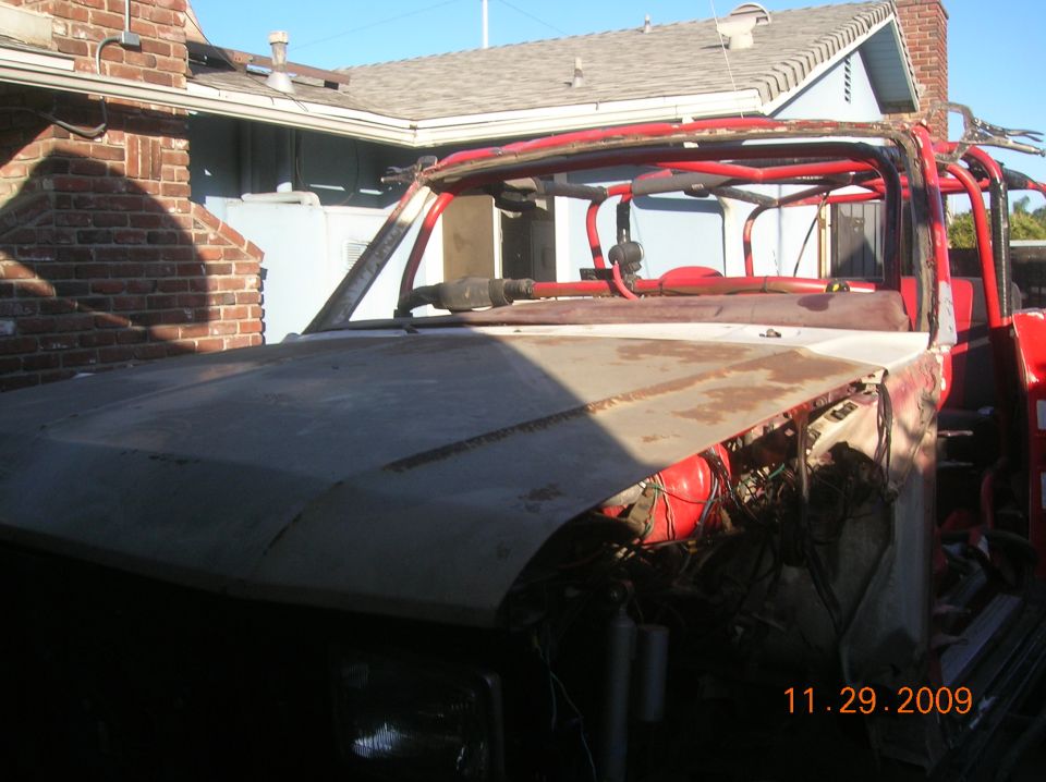 Red roll cage over a white and gray vehicle with visible date 11.29.2009