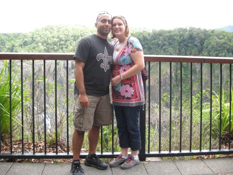 2008 Ford F-250 - couple standing arm-in-arm at a metal railing overlooking forested hills; the man wears a black fleur-de-lis t-shirt.