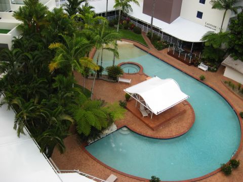 2008 Ford F-250 - A resort pool area features lush palm trees, a hot tub, and a covered seating area with lounge chairs.