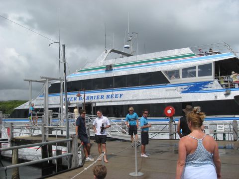 2008 Ford F-250 - People gather on a pier next to the 'WATER BARRIER REEF' ferry on a cloudy day.