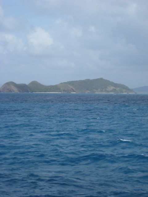 2008 Ford F-250 - A scenic view of islands in the ocean, with rolling green hills and a cloudy sky overhead.