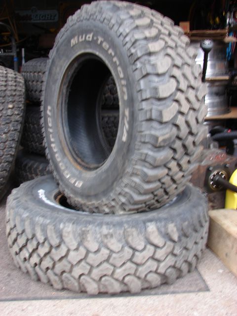 1984 Ford F-250 - A close-up view of two BFGoodrich Mud-Terrain T/A tires, with the top tire showing its tread pattern and sidewall text.