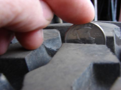 1984 Ford F-250 - A quarter is used to measure the tread depth of a tire, indicating wear.