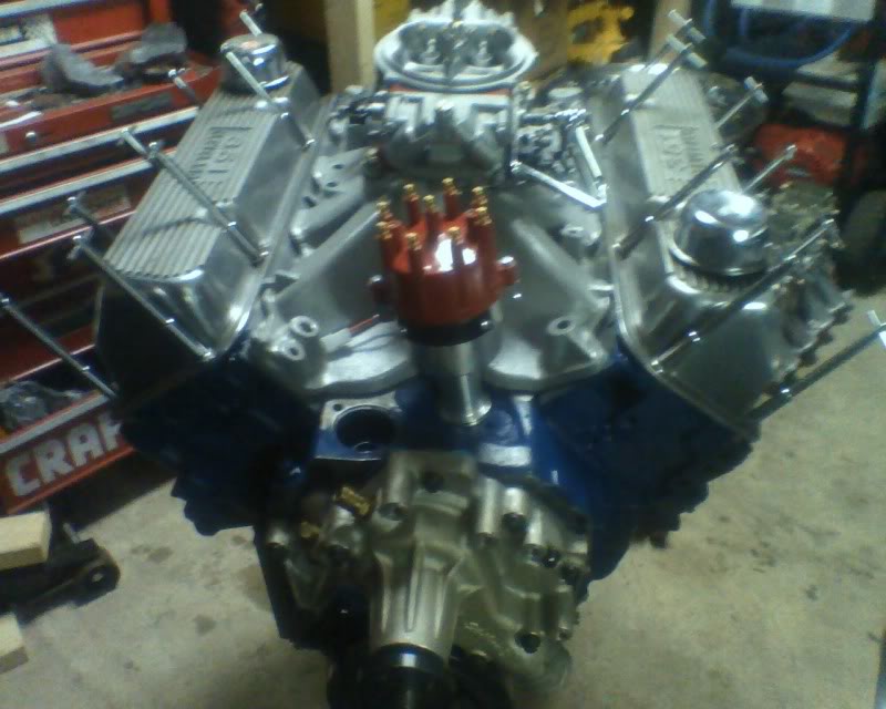 Chrome valve covers on a V8 engine with a red distributor cap