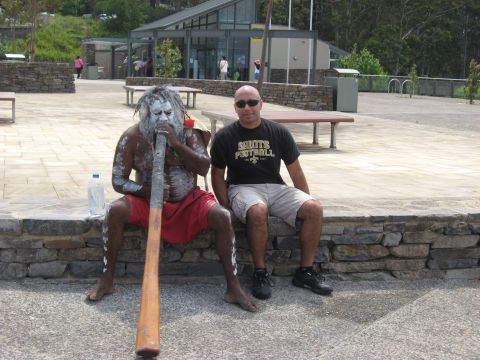 2008 Ford F-250 - Two men are seated outdoors, one playing a didgeridoo while the other watches.