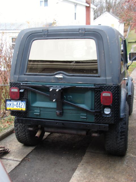 1979 Jeep CJ7 - Rear view of a 1979 Jeep CJ7, showing the spare tire mount and custom diamond plate bumper.