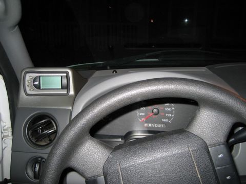 2004 Ford F-150 - The interior of a truck shows the dashboard, steering wheel, and a digital monitoring device.