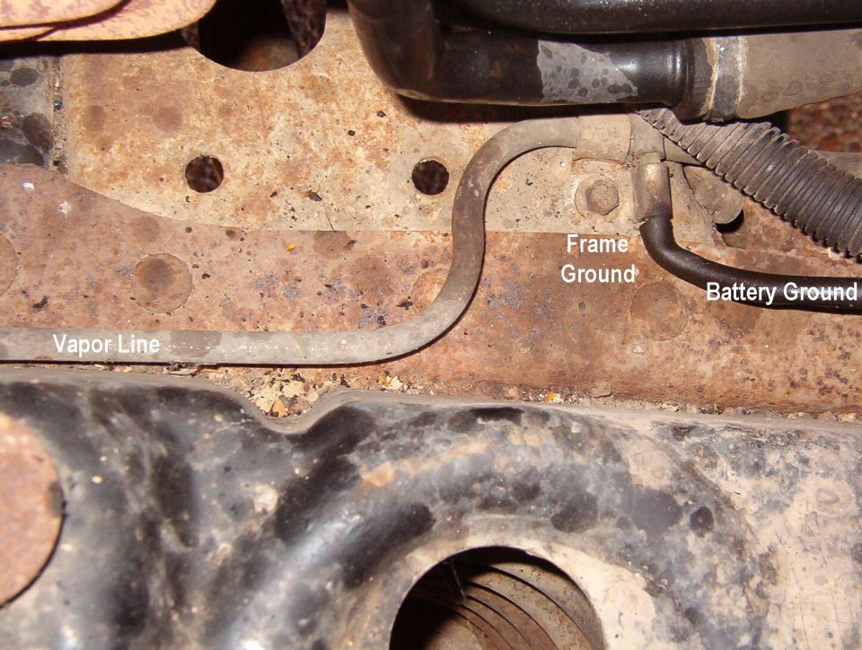 Underbody close-up with labels pointing to vapor line, frame ground, battery ground